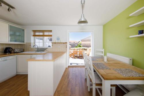 a kitchen with a table and a dining room at Family Seaside Escape - 5 Mins to Beach in Earnley