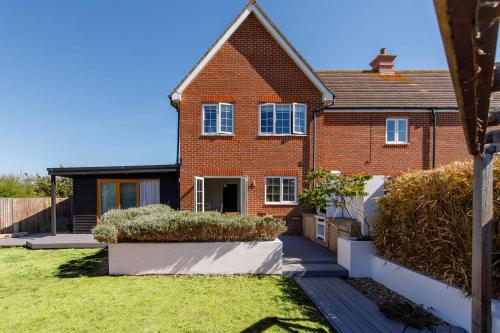 a brick house with a lawn in front of it at Family Seaside Escape - 5 Mins to Beach in Earnley
