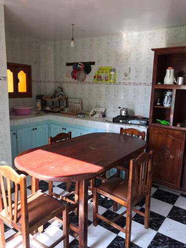 a kitchen with a wooden table and some chairs at LoveWave House in Agadir