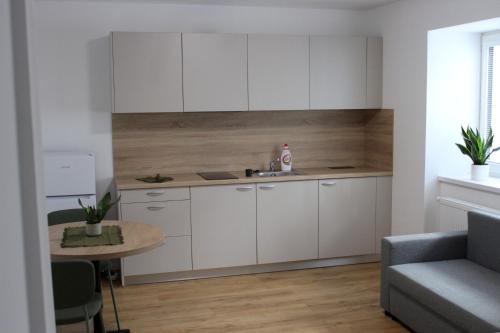a kitchen with white cabinets and a table in a room at KAVE Obchodná Apartments in Bratislava