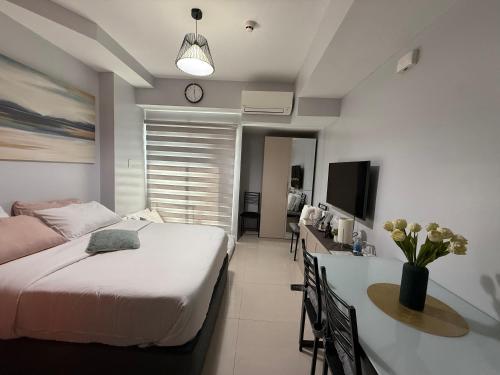 a bedroom with a bed and a desk and a tv at RGM PLACE in Davao City