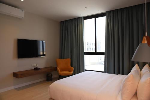ein Hotelzimmer mit einem Bett und einem Fernseher in der Unterkunft شُقَقُ دُخُولٍ ذاتِيّة in Quai