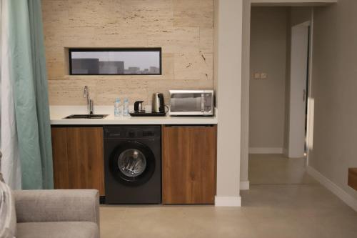 eine Küche mit Waschmaschine und Spüle in der Unterkunft شُقَقُ دُخُولٍ ذاتِيّة in Quai