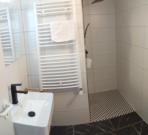 Un baño blanco con lavabo y ducha en Schlafort, en Porta Westfalica