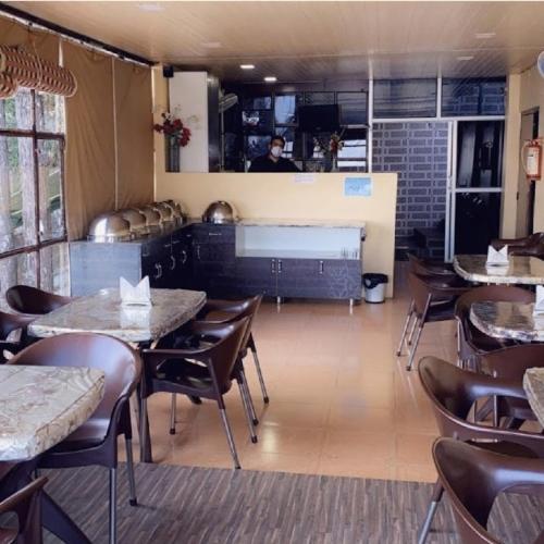 a restaurant with tables and chairs and a chef in the kitchen at Suncrest Trails Resort in Lansdowne
