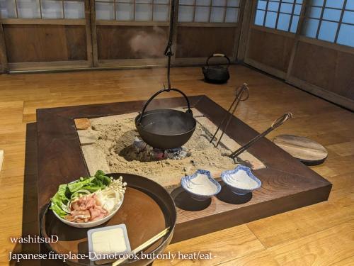 a wok on a stove with a bowl of food at 小川町 古民家田淵 -villa tabuchi- in Ogose
