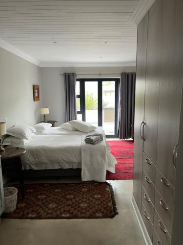 GlentanaにあるLouwtel Annexのベッドルーム1室(ベッド1台付)、窓付きのドアが備わります。