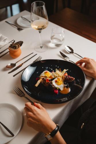 a person sitting at a table with a plate of food at The Vinea Collection Hotel by Piamonte Hotels in Monção