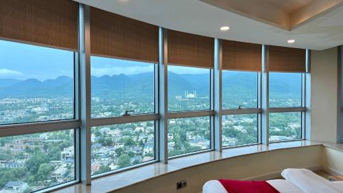 a bedroom with a bunch of windows at Centaurus Three Bed Mountain View in Islamabad