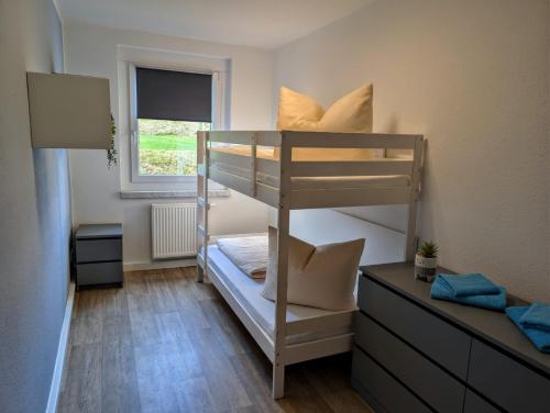 a small room with a bunk bed and a window at Ferienwohnung August 29 in Gelenau