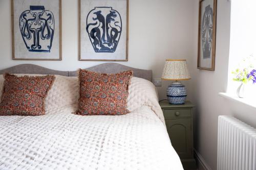 SelhamにあるAmbersham Houseのベッドルーム1室(枕付きのベッド1台、壁に絵画付)