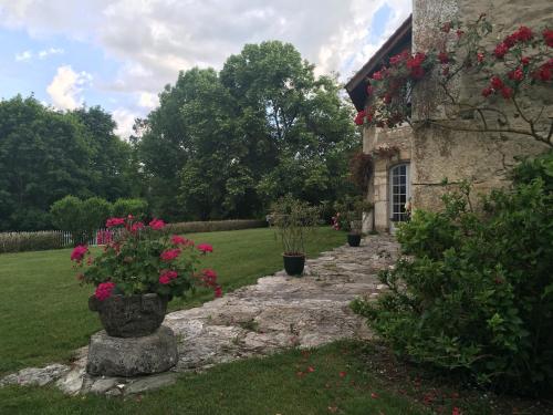 Un camino de piedra que conduce a una casa con flores. en Chambre Chez L'habitant, en Sermérieu