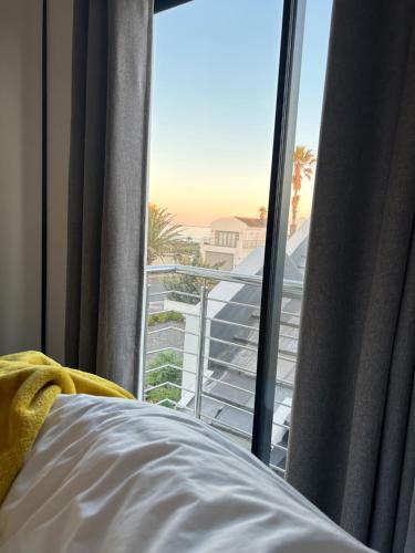 a bedroom with a bed and a view of the ocean at 6 on Third in Stompneusbaai