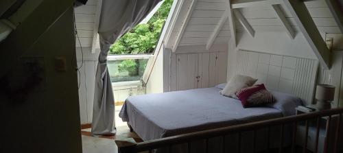 ein Bett mit zwei Kissen in einem Zimmer mit einem Fenster in der Unterkunft Rojaiju in Punta del Este