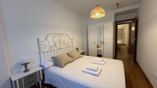 ein Schlafzimmer mit einem weißen Bett mit Handtüchern darauf in der Unterkunft Rincon de Pepo in Villanúa