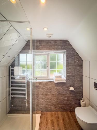 a bathroom with a shower and a toilet and a window at The Crescent Turner Hotel in Whitstable