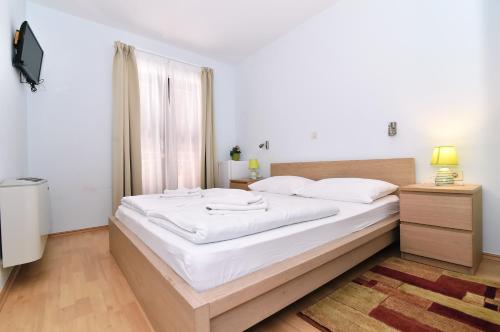a large white bed in a room with a window at Villa Maravilla in Jadranovo