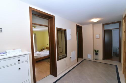 a room with a bathroom with a mirror and a bedroom at Villa Maravilla in Jadranovo