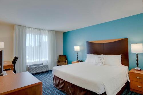 a hotel room with a large bed and a desk at Fairfield by Marriott Inn & Suites Melbourne West/Palm Bay in Melbourne