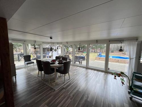 a living room with a dining room table and chairs at Beautiful and private with heated pool & hot tub in Ljungbyhed
