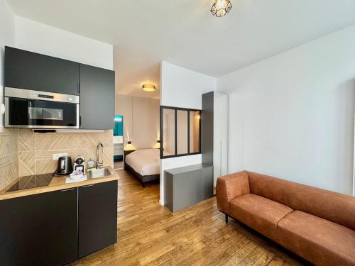a living room with a couch and a bed in a room at Wellness Suite Ponsardin RDC - Reims Centre in Reims