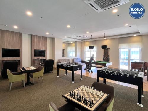 a living room with chess tables and a room with a pool table at Luxury Studio Stay at Saint Dominique in Mandurriao