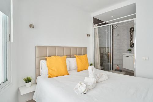 a bedroom with a large white bed with yellow pillows at Las Tortugas Bungalow Beach in Arona