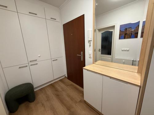 eine Küche mit weißen Schränken, einem Schreibtisch und einem Stuhl in der Unterkunft Premium Yacht Ausstattung Apartments Hotel 3 in Hamburg