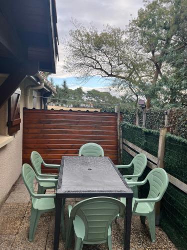 Una mesa y sillas en un patio. en À deux pas du courant, en Mimizan-Plage