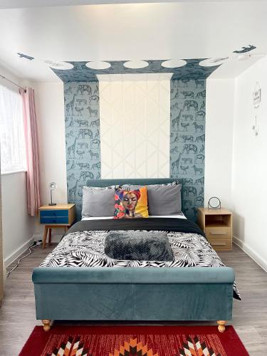 ein Schlafzimmer mit einem großen Bett mit blauen Wänden in der Unterkunft 12 Penn Gardens- Apart 2 in Friern Barnet