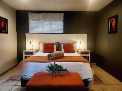a bedroom with a large bed and two tables at The Lantern Guesthouse in Bloemfontein
