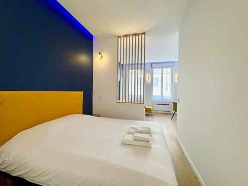 a bedroom with a large white bed with two towels on it at Wellness Suite Ponsardin 1 - Reims Centre in Reims