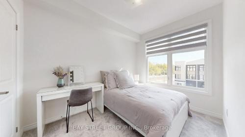 een slaapkamer met een bed, een bureau en een raam bij Modern in Richmond Hill in Richmond Hill