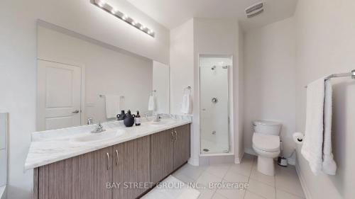 een witte badkamer met een wastafel en een toilet bij Modern in Richmond Hill in Richmond Hill