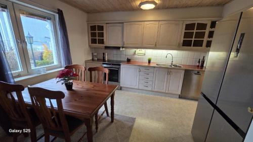 ストックホルムにあるCozy house in peaceful location with close access to amenitiesの木製のテーブルと冷蔵庫のあるキッチン