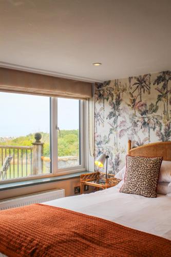 a bedroom with a bed and a large window at The Crescent Turner Hotel in Whitstable