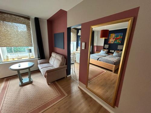 een woonkamer met een spiegel en een bed bij Brandt Apartments in Erfurt