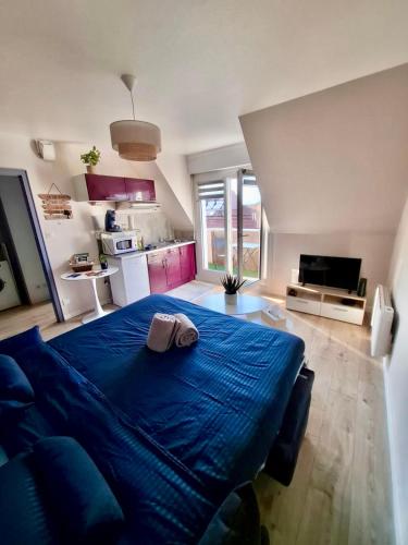 een groot blauw bed in een kamer met een keuken bij Au Nichoir in Erstein