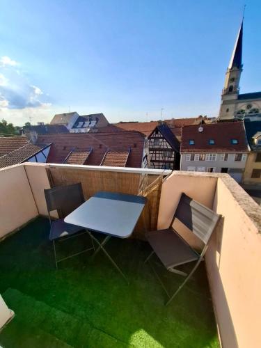 een tafel en twee stoelen op een dak bij Au Nichoir in Erstein