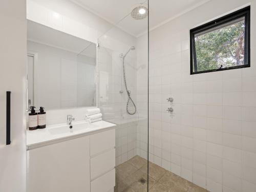 a white bathroom with a sink and a shower at Wren Studio - Private One-Bedroom Studio Nestled in Bushland in Yallingup