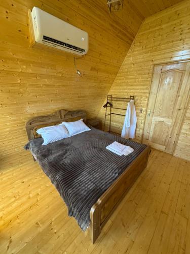 a bedroom with a bed in a wooden room at Dzaria cottage in Martvili