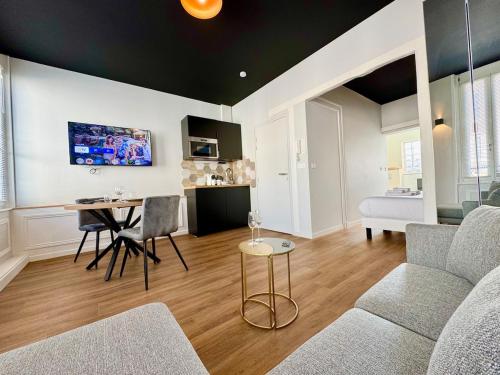 a living room with a couch and a table at Wellness Suite Ponsardin 2 - Reims Centre in Reims