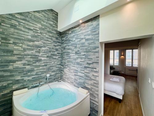 a bathroom with a jacuzzi tub in a room at Wellness Suite Ponsardin 2 - Reims Centre in Reims