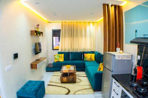 a living room with a blue couch and a table at Belle appartement a mahdia plage in Kenitra