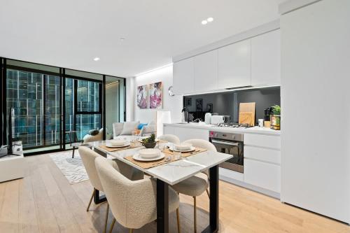 a kitchen and dining room with a table and chairs at Skyrise City Apartment with Pool Gym & Sauna in Melbourne
