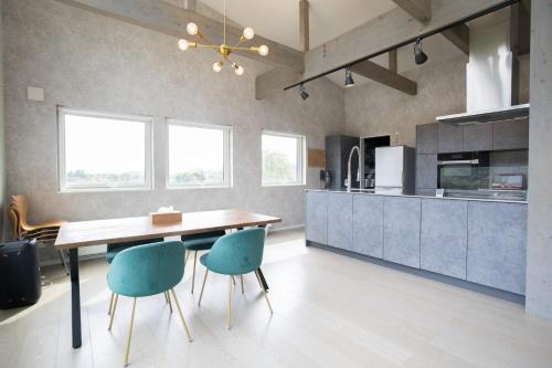 a kitchen with a wooden table and blue chairs at Grey House Niseko in Niseko
