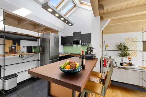 a kitchen with a wooden table with a bowl of fruit on it at Svyvo Cologne-Esch Design Apartment in Cologne