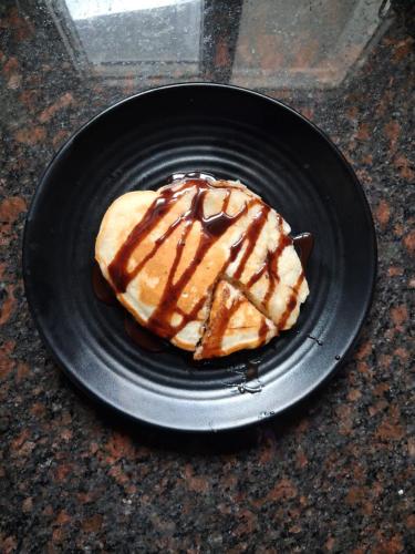 - un dessert sur une assiette noire dans l'établissement Gitanjali Homestay by Lake Pichola Udaipur, à Udaipur