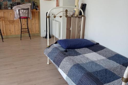 a bedroom with a bed with a blue and white quilt at une terrasse en ville in Langon