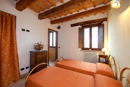 une chambre avec deux lits et une commode et deux fenêtres dans l'établissement Historic Villa With Pool In Marche Hills, à SantʼAngelo in Pontano
